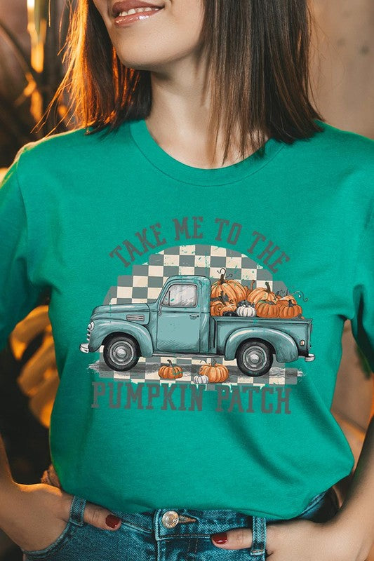 A woman wearing the "Take Me To The Pumpkin Patch Graphic Tee" featuring an illustration of a teal truck carrying pumpkins and the text "Take Me to the Pumpkin Patch." She has a green plaid shirt draped over her shoulders, creating a perfect match for Family Group Uniforms.