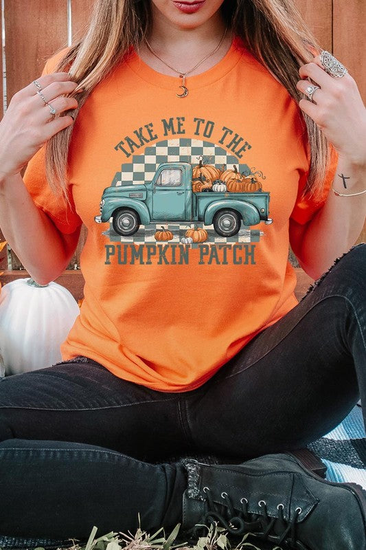 A woman wearing the "Take Me To The Pumpkin Patch Graphic Tee" featuring an illustration of a teal truck carrying pumpkins and the text "Take Me to the Pumpkin Patch." She has a green plaid shirt draped over her shoulders, creating a perfect match for Family Group Uniforms.