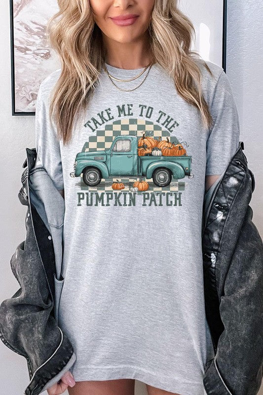 A woman wearing the "Take Me To The Pumpkin Patch Graphic Tee" featuring an illustration of a teal truck carrying pumpkins and the text "Take Me to the Pumpkin Patch." She has a green plaid shirt draped over her shoulders, creating a perfect match for Family Group Uniforms.