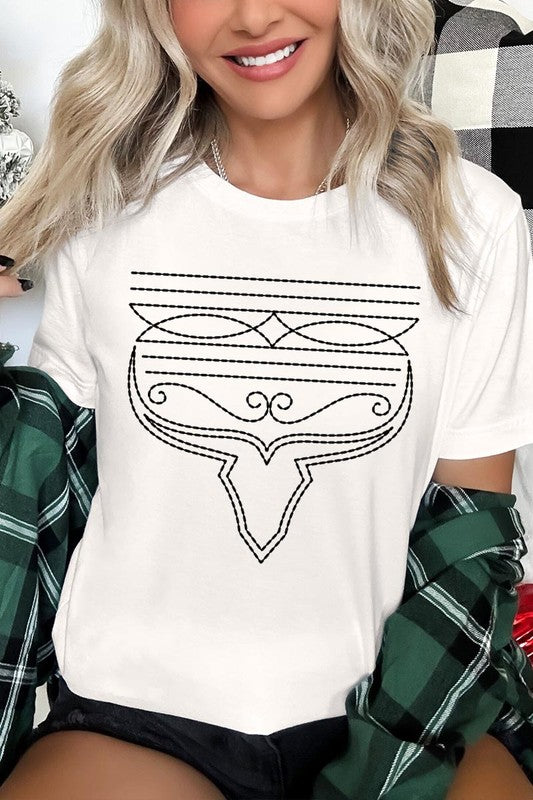 A person wearing the Western Boot Stitch Graphic Tee, featuring a geometric design and holding the bottom of the shirt, has a denim jacket draped over their shoulders.