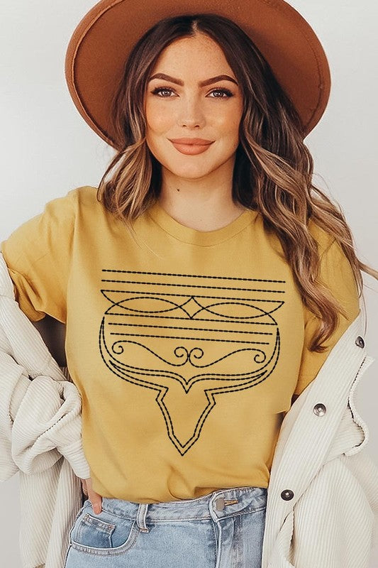 A person wearing the Western Boot Stitch Graphic Tee, featuring a geometric design and holding the bottom of the shirt, has a denim jacket draped over their shoulders.