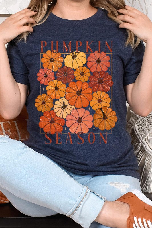 Person wearing a Pumpkin Season Boho Graphic Tee adorned with floral pumpkin designs, paired with a beige cardigan.