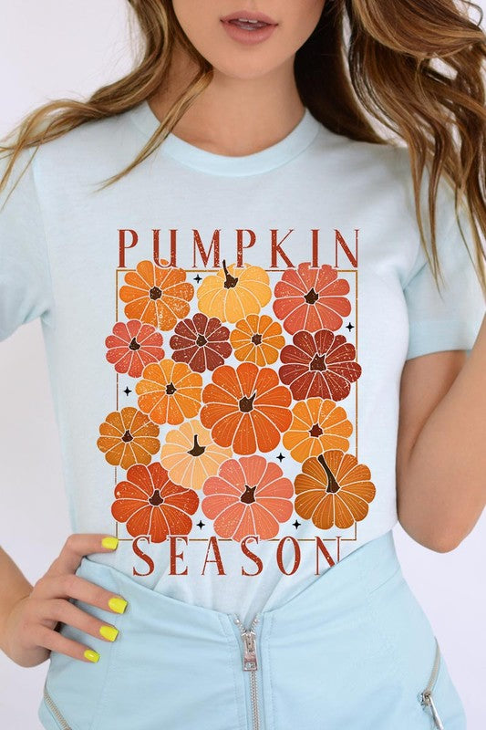 Person wearing a Pumpkin Season Boho Graphic Tee adorned with floral pumpkin designs, paired with a beige cardigan.