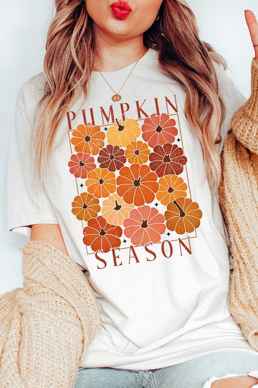 Person wearing a Pumpkin Season Boho Graphic Tee adorned with floral pumpkin designs, paired with a beige cardigan.