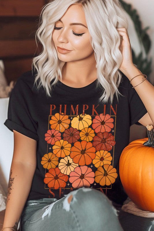 Person wearing a Pumpkin Season Boho Graphic Tee adorned with floral pumpkin designs, paired with a beige cardigan.