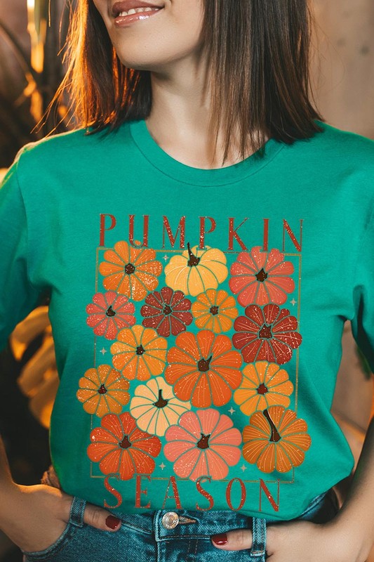 Person wearing a Pumpkin Season Boho Graphic Tee adorned with floral pumpkin designs, paired with a beige cardigan.