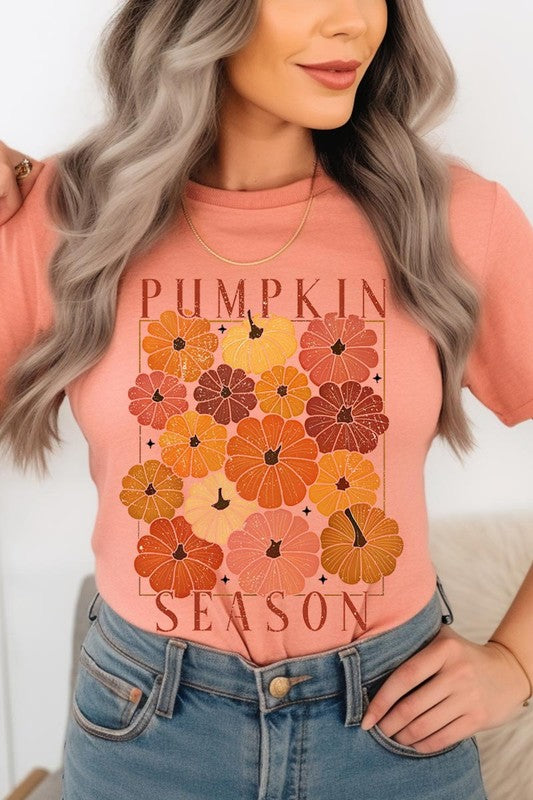 Person wearing a Pumpkin Season Boho Graphic Tee adorned with floral pumpkin designs, paired with a beige cardigan.