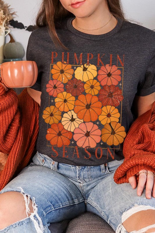 Person wearing a Pumpkin Season Boho Graphic Tee adorned with floral pumpkin designs, paired with a beige cardigan.