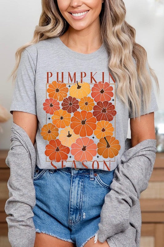 Person wearing a Pumpkin Season Boho Graphic Tee adorned with floral pumpkin designs, paired with a beige cardigan.