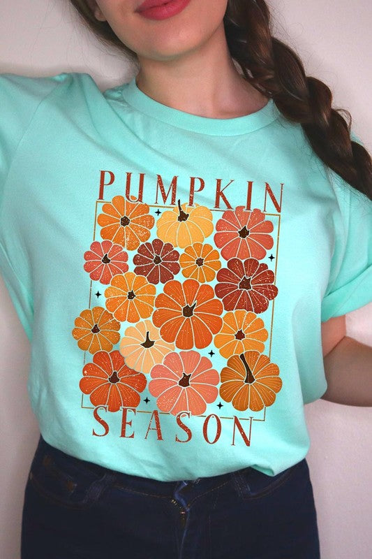 Person wearing a Pumpkin Season Boho Graphic Tee adorned with floral pumpkin designs, paired with a beige cardigan.