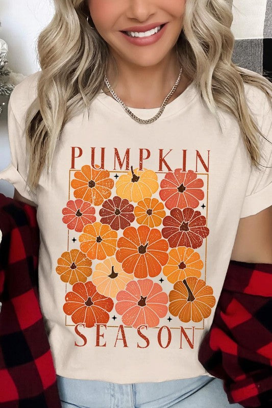 Person wearing a Pumpkin Season Boho Graphic Tee adorned with floral pumpkin designs, paired with a beige cardigan.