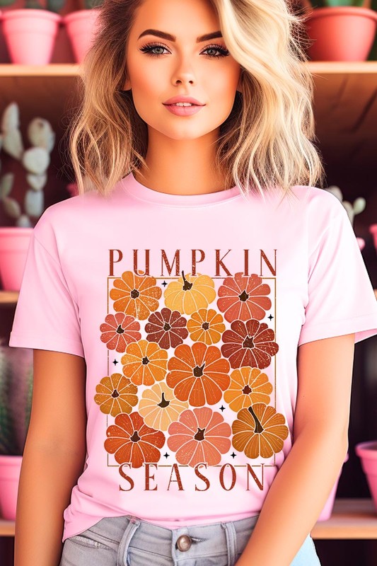 Person wearing a Pumpkin Season Boho Graphic Tee adorned with floral pumpkin designs, paired with a beige cardigan.