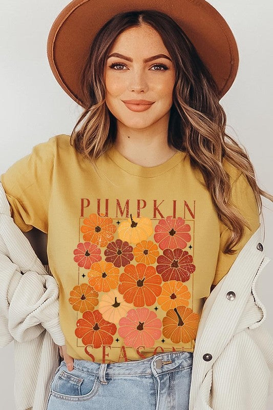 Person wearing a Pumpkin Season Boho Graphic Tee adorned with floral pumpkin designs, paired with a beige cardigan.