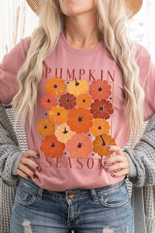 Person wearing a Pumpkin Season Boho Graphic Tee adorned with floral pumpkin designs, paired with a beige cardigan.