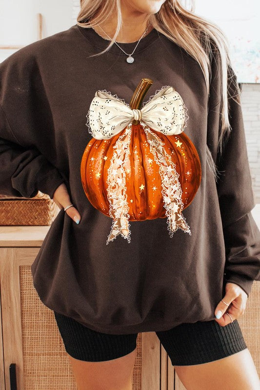 A person wearing the Coquette bow Halloween Pumpkin Fleece Sweatshirt, which features a black unisex crew neck design with a printed Halloween pumpkin graphic adorned with a large, lacy white bow.