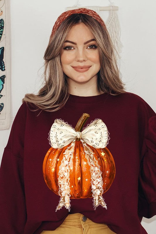 A person wearing the Coquette bow Halloween Pumpkin Fleece Sweatshirt, which features a black unisex crew neck design with a printed Halloween pumpkin graphic adorned with a large, lacy white bow.