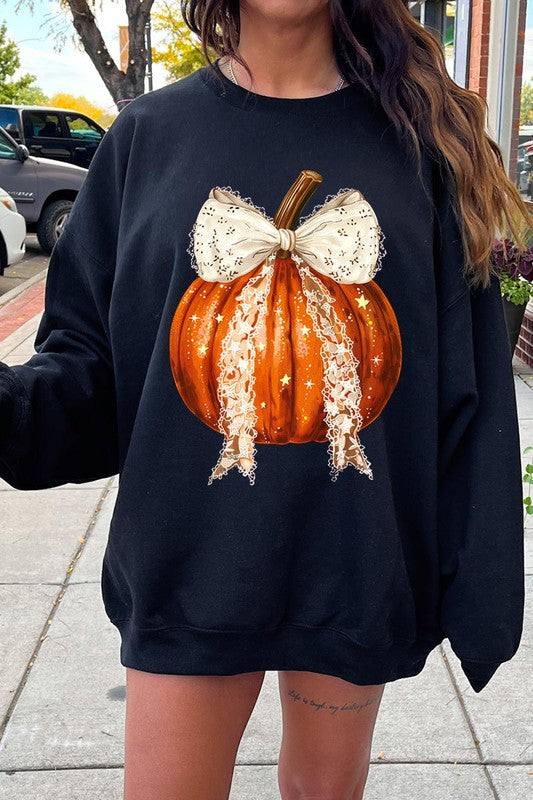 A person wearing the Coquette bow Halloween Pumpkin Fleece Sweatshirt, which features a black unisex crew neck design with a printed Halloween pumpkin graphic adorned with a large, lacy white bow.