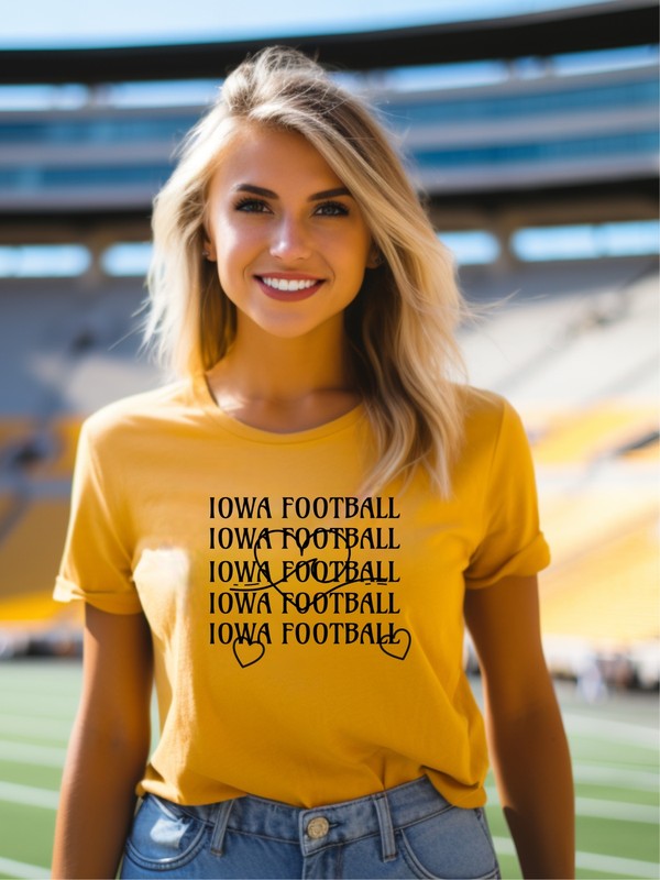 Person standing with hands on hips wearing an Iowa Football Wave Heart Graphic Crew Tee and black shorts.