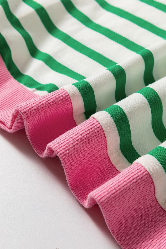 A person wearing the Cotton Stripe Drop Shoulder Sweatshirt, which features green stripes and pink cuffs, is facing away from the camera against a pink background.