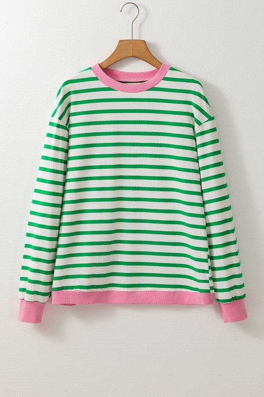 A person wearing the Cotton Stripe Drop Shoulder Sweatshirt, which features green stripes and pink cuffs, is facing away from the camera against a pink background.