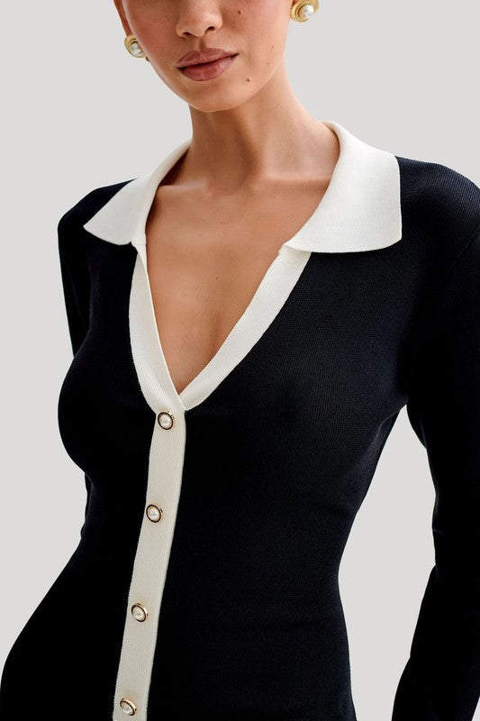 A woman wearing the WOMEN FASHION SWEATER DRESS, a fitted black dress with a white collar, button-down front, long sleeves, and a ruffled white hem stands against a plain background.