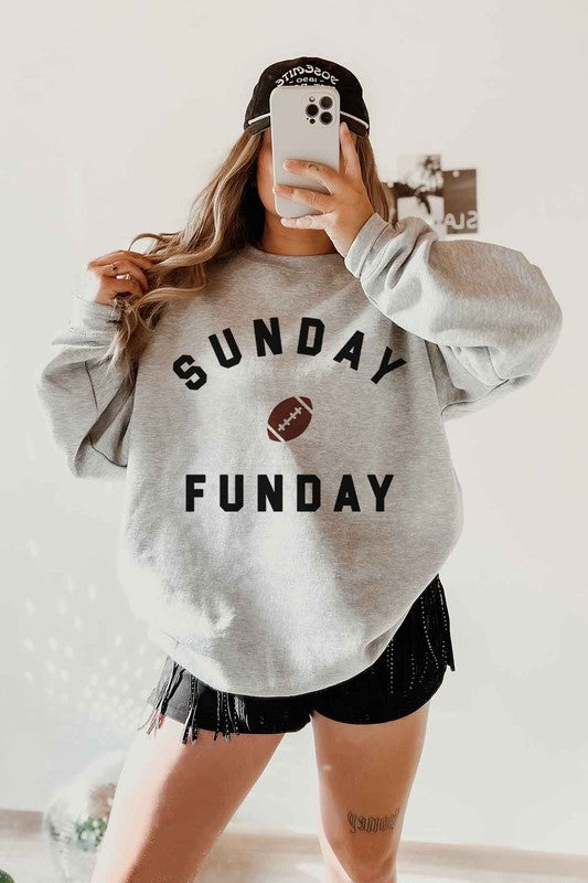 A person wearing a SUNDAY FUN DAY FOOTBALL GRAPHIC SWEATSHIRT, taking a selfie.