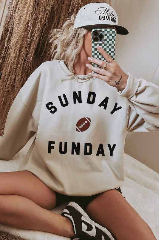 A person wearing the SUNDAY FUN DAY FOOTBALL OVERSIZED SWEATSHIRT, made of premium cotton and featuring the text "Sunday Funday" along with an image of a football on the front, perfect for a football game.