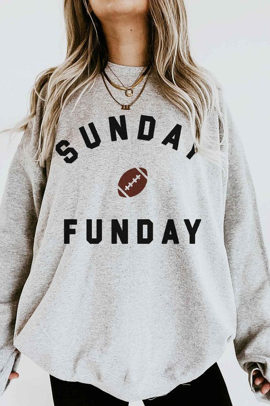 A person wearing the SUNDAY FUN DAY FOOTBALL OVERSIZED SWEATSHIRT, made of premium cotton and featuring the text "Sunday Funday" along with an image of a football on the front, perfect for a football game.