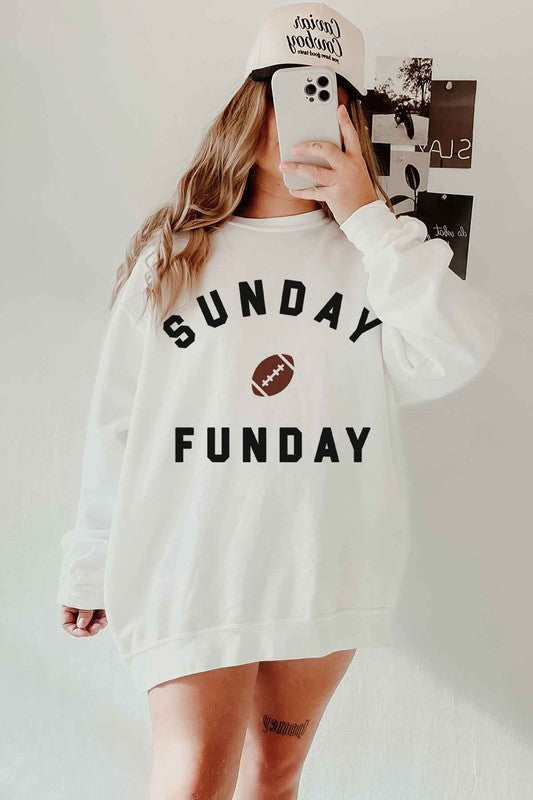 A person wearing the SUNDAY FUN DAY FOOTBALL OVERSIZED SWEATSHIRT, made of premium cotton and featuring the text "Sunday Funday" along with an image of a football on the front, perfect for a football game.