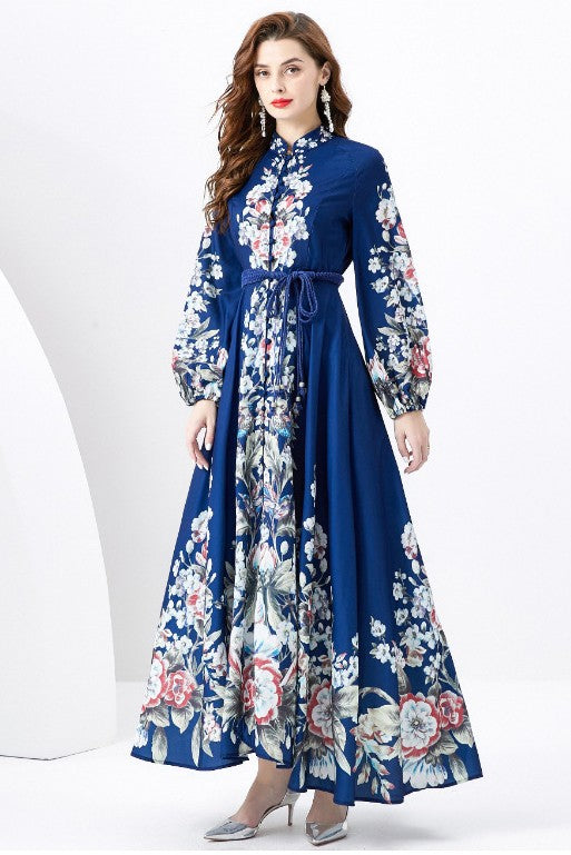 A woman in a WOMEN FASHION LONG MAXI DRESS with a blue long-sleeve and floral multi-print stands against a white background.