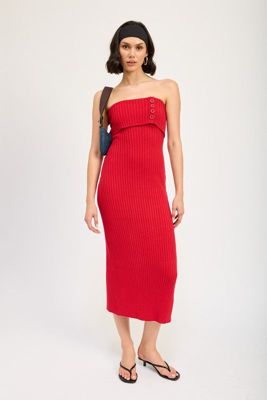 A woman stands against a plain background, wearing a red Fold Over Ribbed Tube Dress with buttons on the bodice. Made from imported fabric, she pairs it with a black headband, a small shoulder bag, and black flip-flops. This outfit is size small.