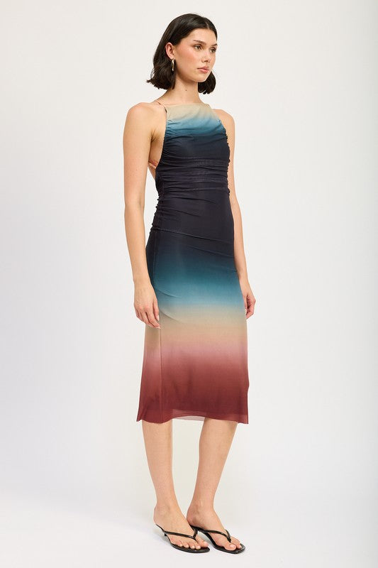 A woman wearing a small HALTER NECK OMBRE MAXI DRESS crafted from a blend of polyester and spandex stands against a plain background, pairing it perfectly with black sandals.