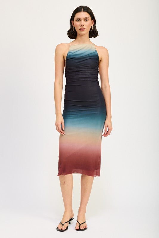 A woman wearing a small HALTER NECK OMBRE MAXI DRESS crafted from a blend of polyester and spandex stands against a plain background, pairing it perfectly with black sandals.