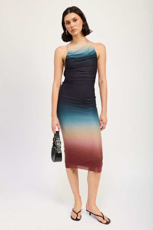 A woman wearing a small HALTER NECK OMBRE MAXI DRESS crafted from a blend of polyester and spandex stands against a plain background, pairing it perfectly with black sandals.