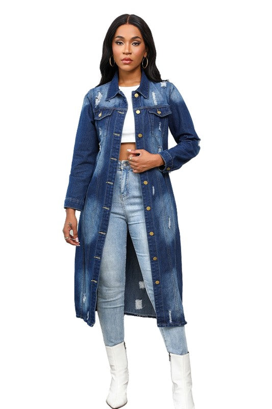 A person wearing the WOMEN MAXI LONG DENIM JACKET over a white crop top, light blue jeans, and white boots showcases a retro longline silhouette.