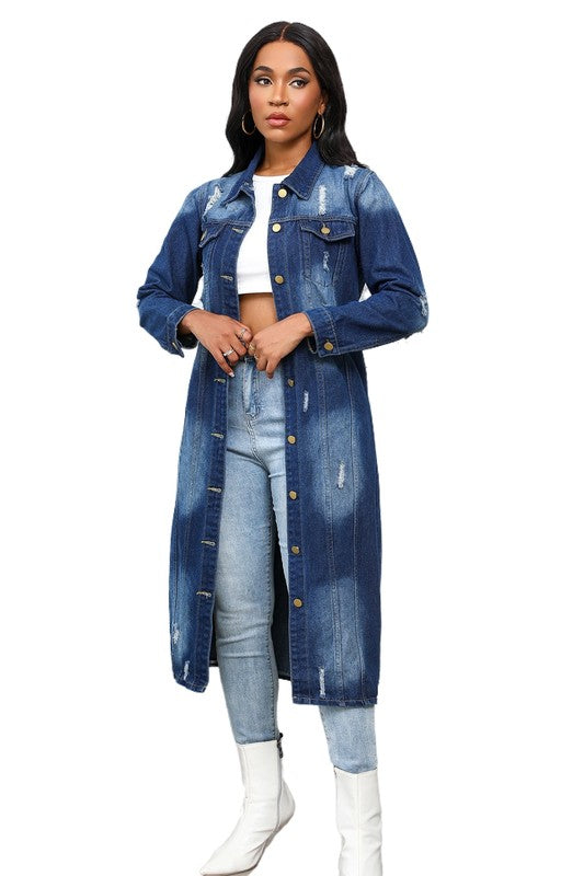 A person wearing the WOMEN MAXI LONG DENIM JACKET over a white crop top, light blue jeans, and white boots showcases a retro longline silhouette.