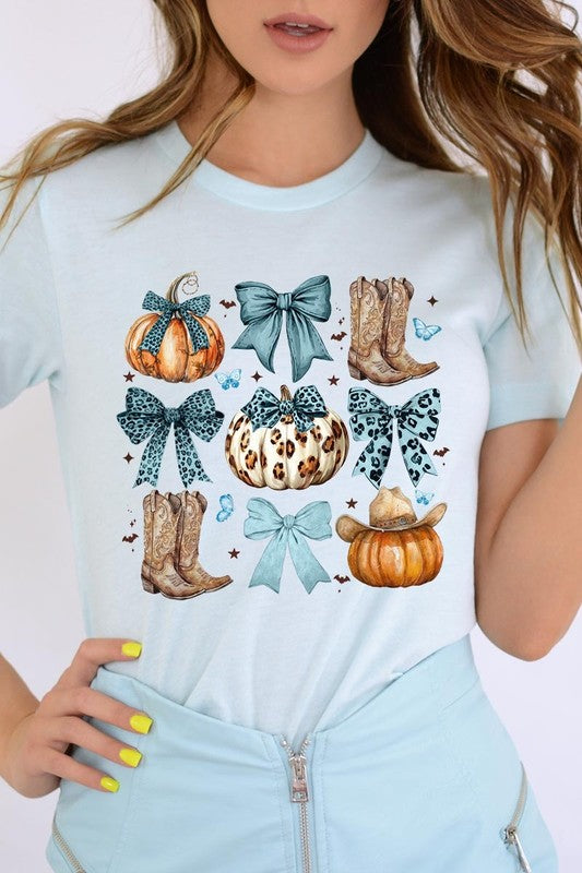 Person wearing a Turquoise Bow Western Fall Graphic Tee featuring illustrations of pumpkins, bows, cowboy hats, and boots adorned with blue and leopard print patterns. The high-quality printed design pairs perfectly with denim shorts and a denim jacket.