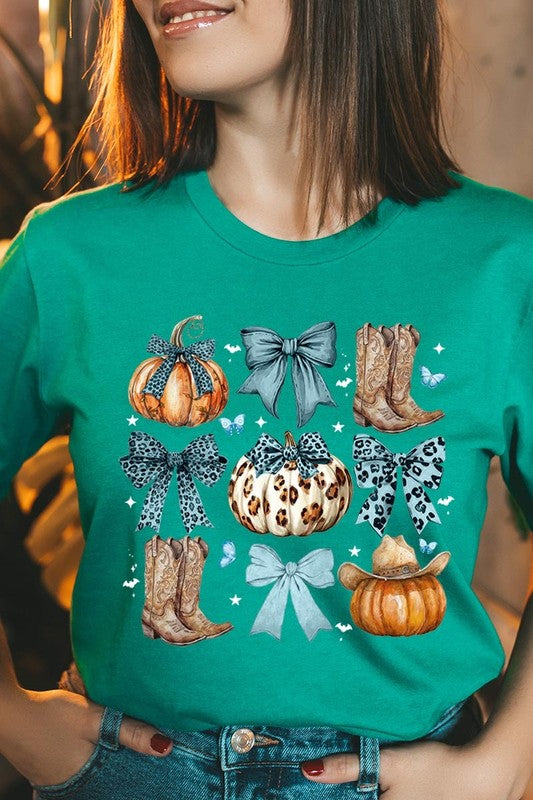 Person wearing a Turquoise Bow Western Fall Graphic Tee featuring illustrations of pumpkins, bows, cowboy hats, and boots adorned with blue and leopard print patterns. The high-quality printed design pairs perfectly with denim shorts and a denim jacket.