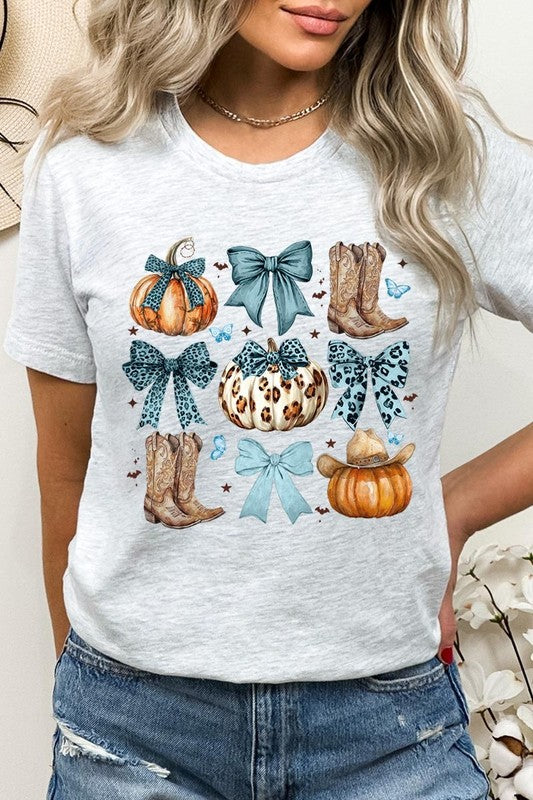 Person wearing a Turquoise Bow Western Fall Graphic Tee featuring illustrations of pumpkins, bows, cowboy hats, and boots adorned with blue and leopard print patterns. The high-quality printed design pairs perfectly with denim shorts and a denim jacket.