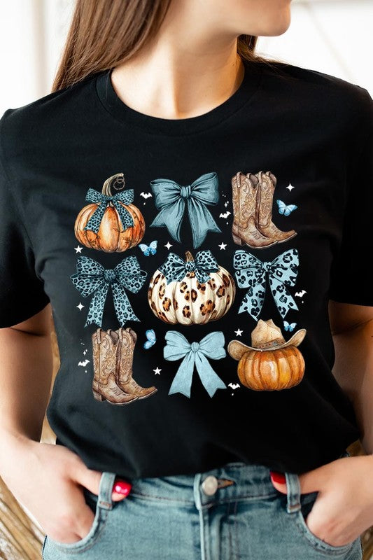 Person wearing a Turquoise Bow Western Fall Graphic Tee featuring illustrations of pumpkins, bows, cowboy hats, and boots adorned with blue and leopard print patterns. The high-quality printed design pairs perfectly with denim shorts and a denim jacket.