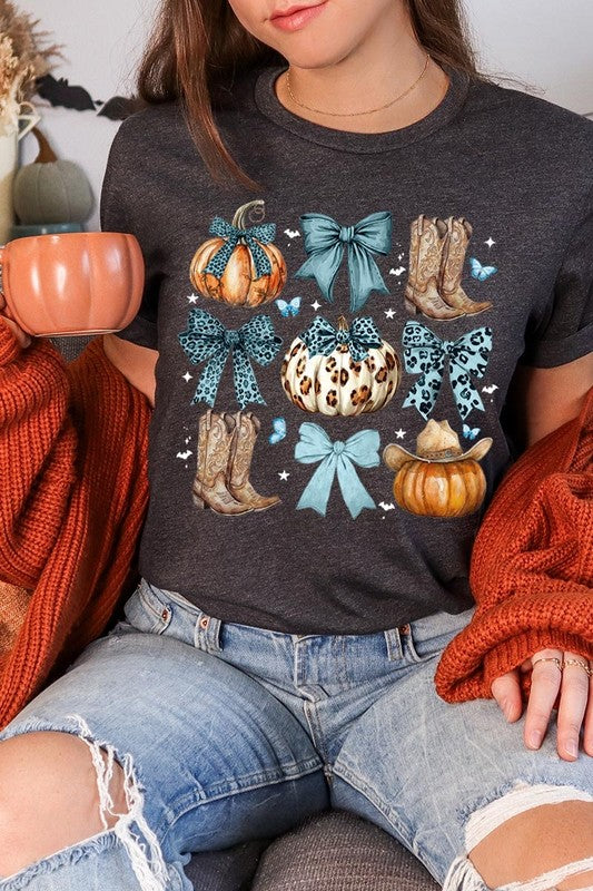 Person wearing a Turquoise Bow Western Fall Graphic Tee featuring illustrations of pumpkins, bows, cowboy hats, and boots adorned with blue and leopard print patterns. The high-quality printed design pairs perfectly with denim shorts and a denim jacket.