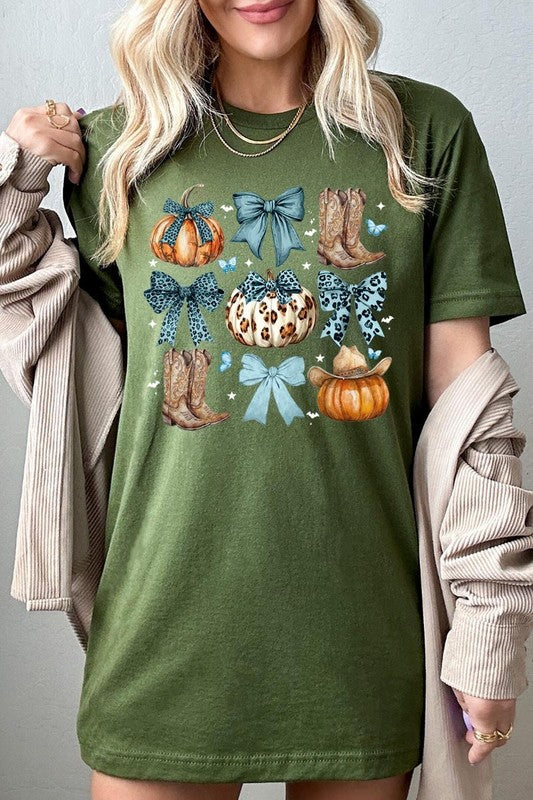 Person wearing a Turquoise Bow Western Fall Graphic Tee featuring illustrations of pumpkins, bows, cowboy hats, and boots adorned with blue and leopard print patterns. The high-quality printed design pairs perfectly with denim shorts and a denim jacket.