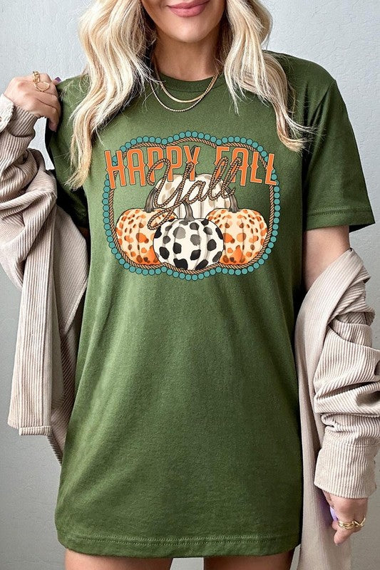 A person wearing a top-quality "Happy Fall Y'all" Graphic Tee featuring a design with three patterned pumpkins, paired with jeans and an orange cardigan, holds a pumpkin-shaped mug.