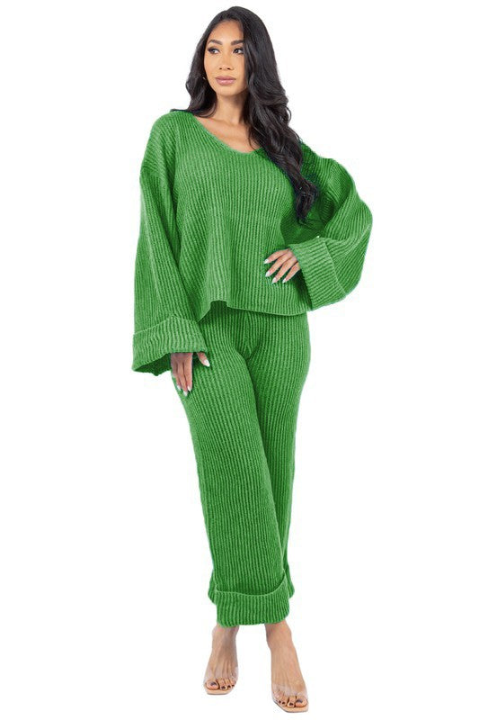 Person posing in the WOMEN FASHION 2PCS SWEATER PANTS SET, featuring a loose-fitting green knit top with bell sleeves and matching wide-leg pants.