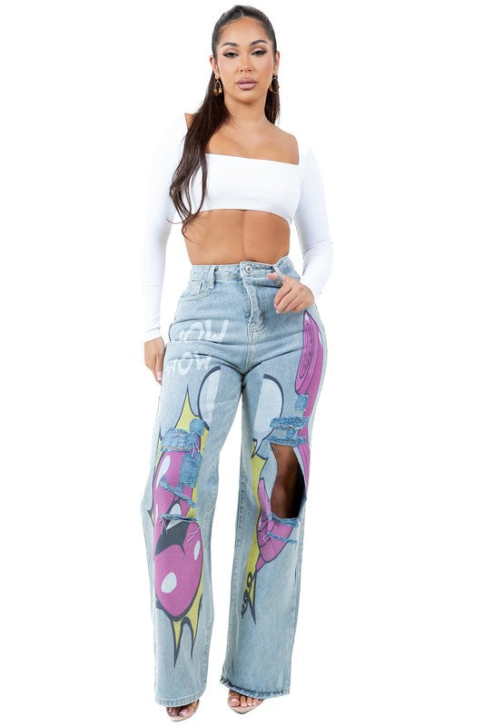 A woman stands wearing a long-sleeve white crop top and WOMEN FASHION DENIM PANTS featuring light blue, high-waist design with comic-style graphics and large knee cutouts.