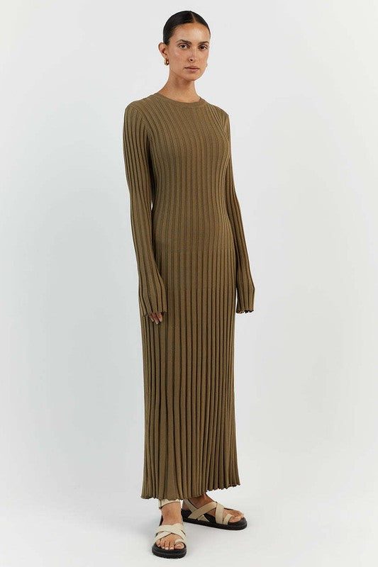 Person standing against a plain background wearing the WOMEN FASHION KNITWEAR LONG MAXI DRESS in olive green, with long sleeves, ribbed texture, a round neckline, and beige sandals.