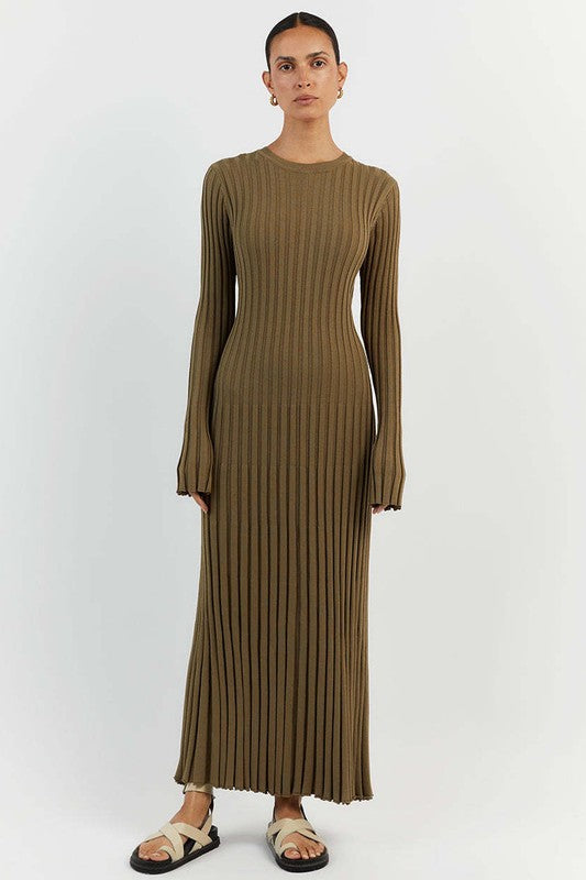 Person standing against a plain background wearing the WOMEN FASHION KNITWEAR LONG MAXI DRESS in olive green, with long sleeves, ribbed texture, a round neckline, and beige sandals.