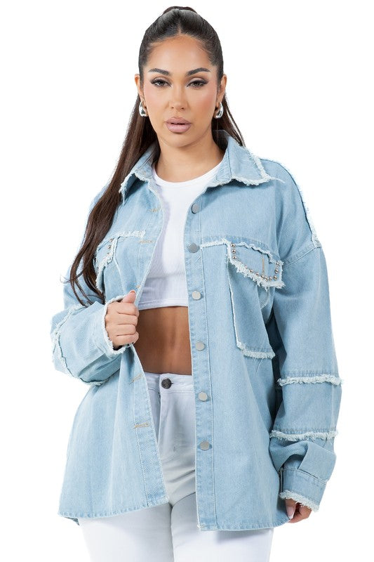 A woman wearing a beige oversize WOMEN FASHION OVERSIZE DENIM SHIRT with long sleeves, a white crop top, blue distressed denim shorts, large hoop earrings, and sunglasses.