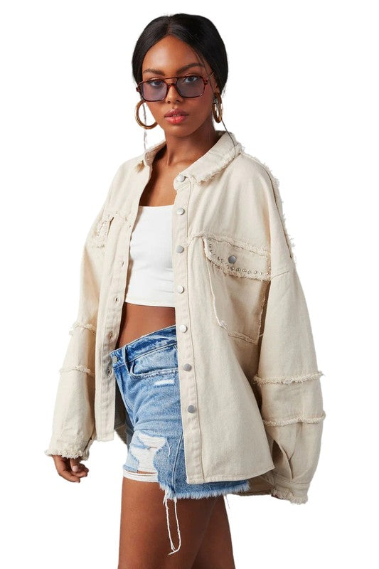 A woman wearing a beige oversize WOMEN FASHION OVERSIZE DENIM SHIRT with long sleeves, a white crop top, blue distressed denim shorts, large hoop earrings, and sunglasses.