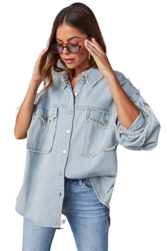 A woman wearing a beige oversize WOMEN FASHION OVERSIZE DENIM SHIRT with long sleeves, a white crop top, blue distressed denim shorts, large hoop earrings, and sunglasses.